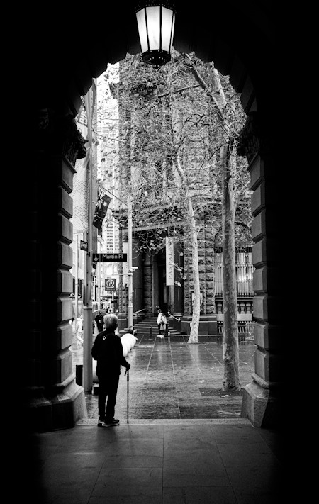 A figure in shadow waiting for the rain to stop